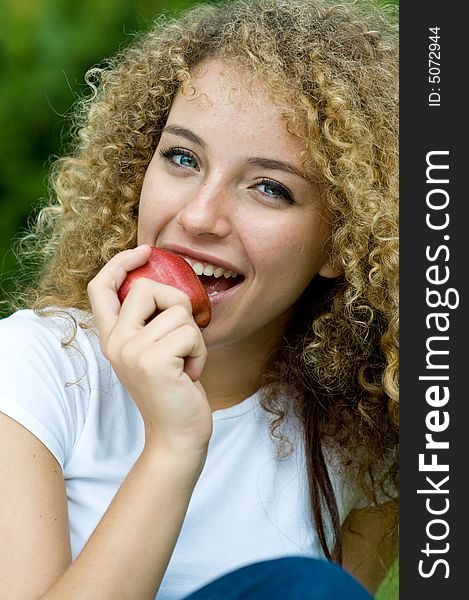 A young attractive woman holding an apple