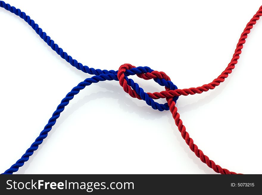 Red and blue ropes tied together by surgical knot, reflection on white background. Red and blue ropes tied together by surgical knot, reflection on white background