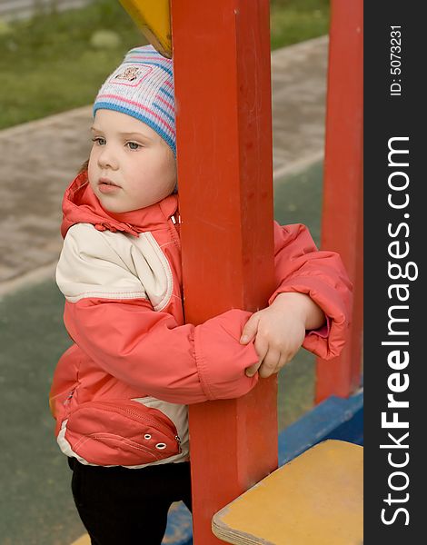 A sad young girl standing near column. A sad young girl standing near column