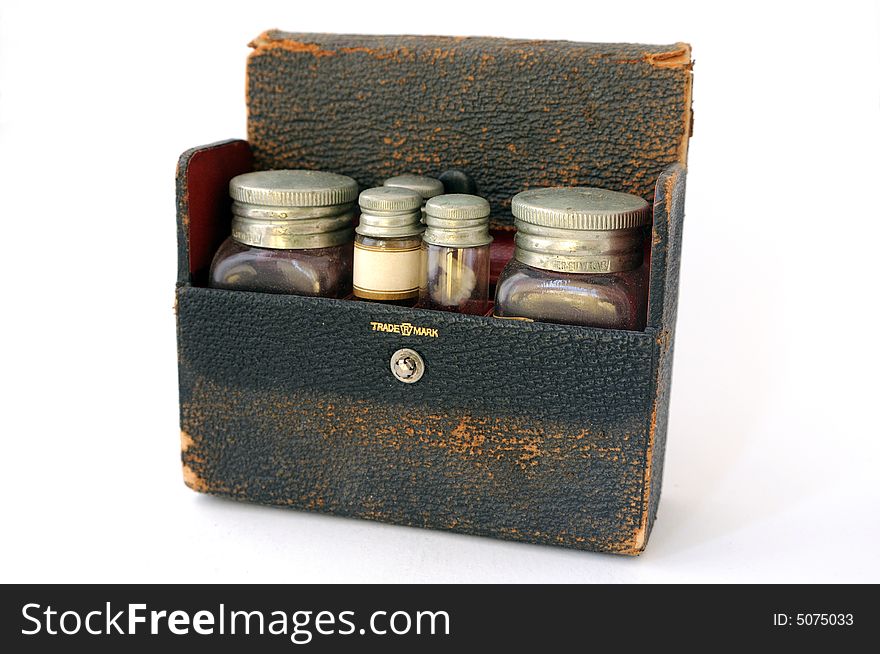 A vintage, distressed leather pharmaceutical case with a red lining, filled with two large bottles and three small vials. One of the vials has a blank label facing forwards. A vintage, distressed leather pharmaceutical case with a red lining, filled with two large bottles and three small vials. One of the vials has a blank label facing forwards.