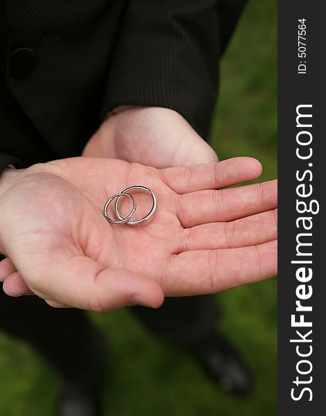 Hands holding wedding rings DOF focus on bands