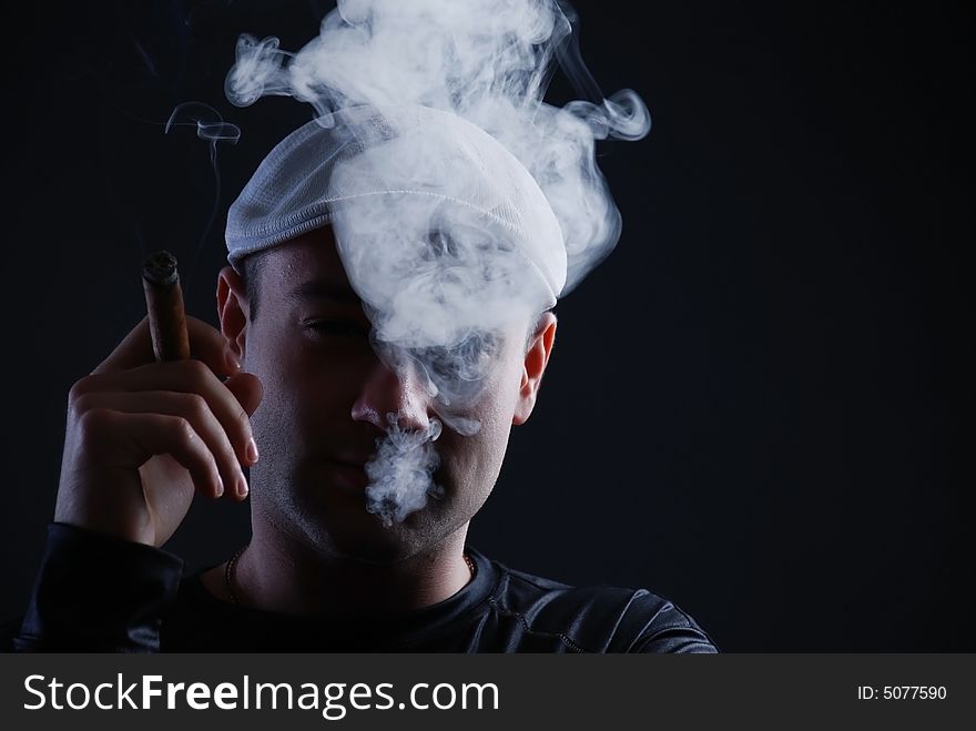 Man with cigare at black background