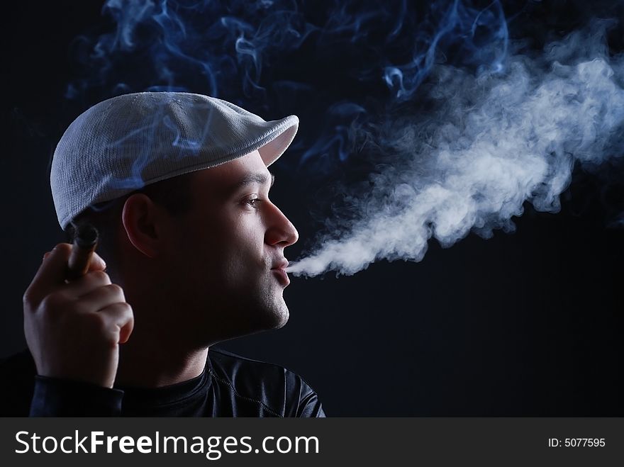 Man with cigare at black background