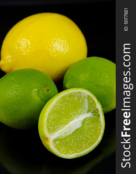 Lemon and lime fruit isolated against a black background. Lemon and lime fruit isolated against a black background