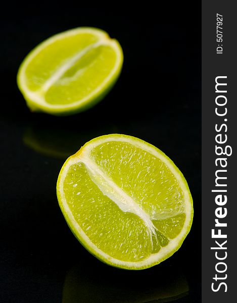 Lemon and lime fruit isolated against a black background. Lemon and lime fruit isolated against a black background