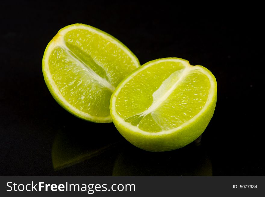 Lemon and lime fruit isolated against a black background. Lemon and lime fruit isolated against a black background