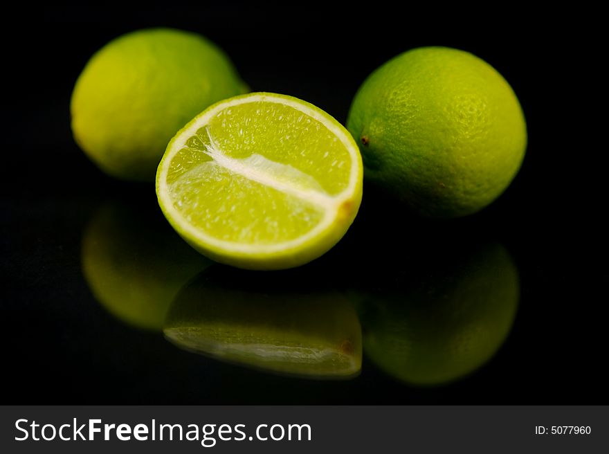 Lemon and lime fruit isolated against a black background. Lemon and lime fruit isolated against a black background