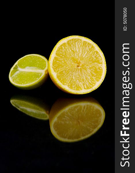 Lemon and lime fruit isolated against a black background. Lemon and lime fruit isolated against a black background