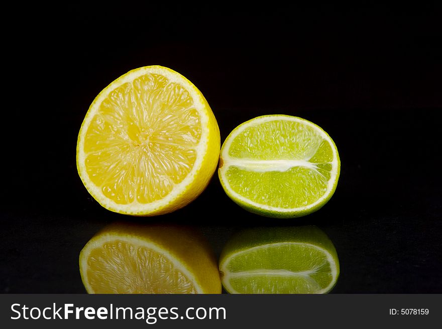 Lemon and lime fruit isolated against a black background. Lemon and lime fruit isolated against a black background