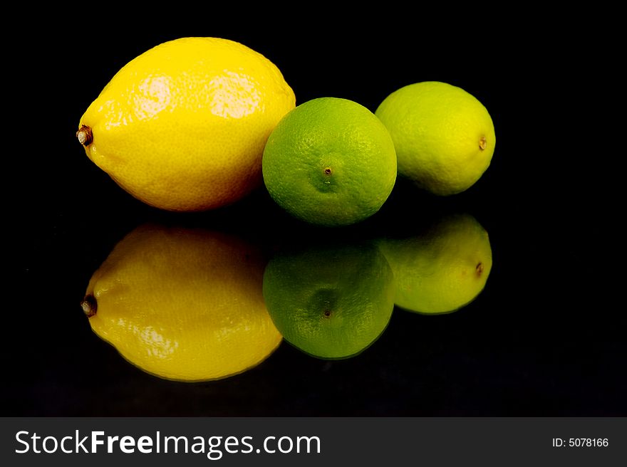 Lemon and lime fruit isolated against a black background. Lemon and lime fruit isolated against a black background