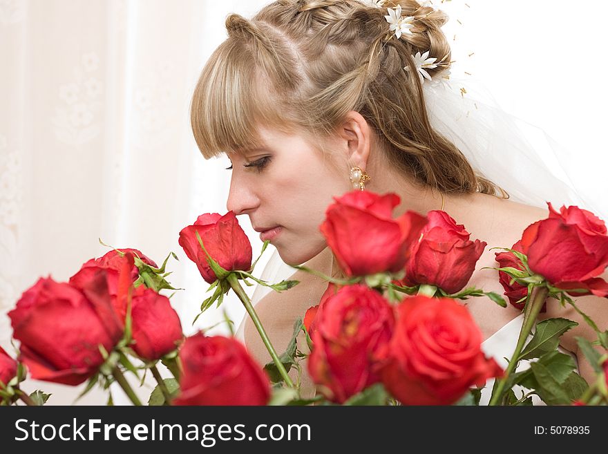 Young bride in wedding wear with bouquet of roses