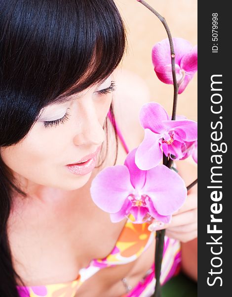 Beautiful asian girl with orchid. Low DOF, focus on eyes