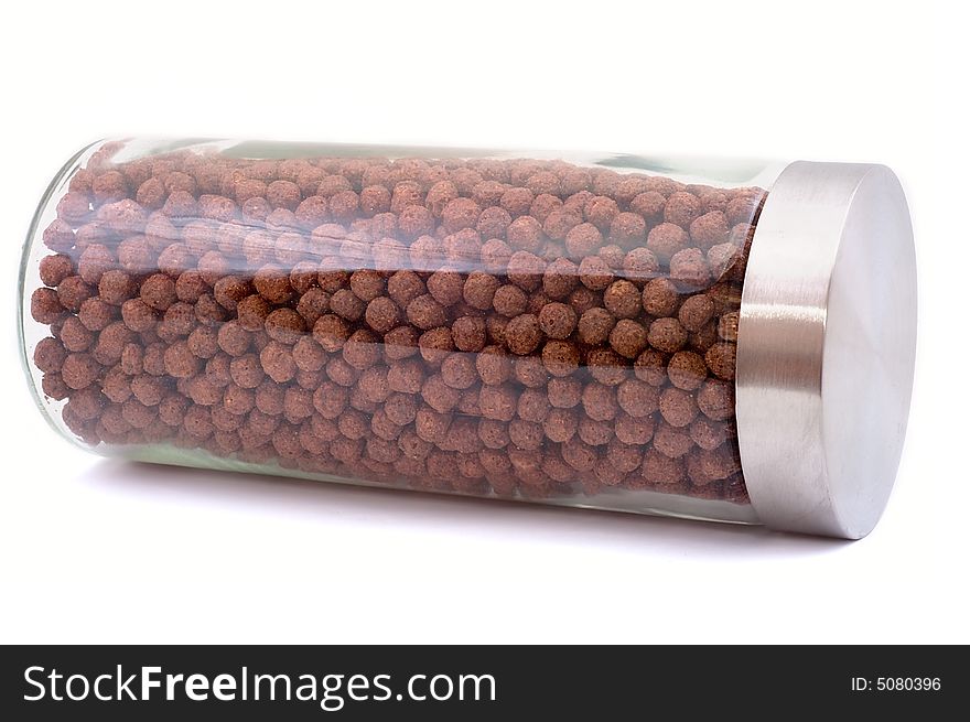 Chocolate chips in glass pot with aluminium cover on white background