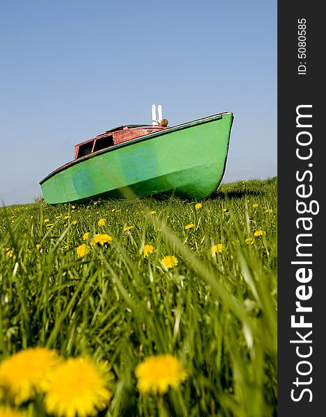 Green boat sailing over spring meadow