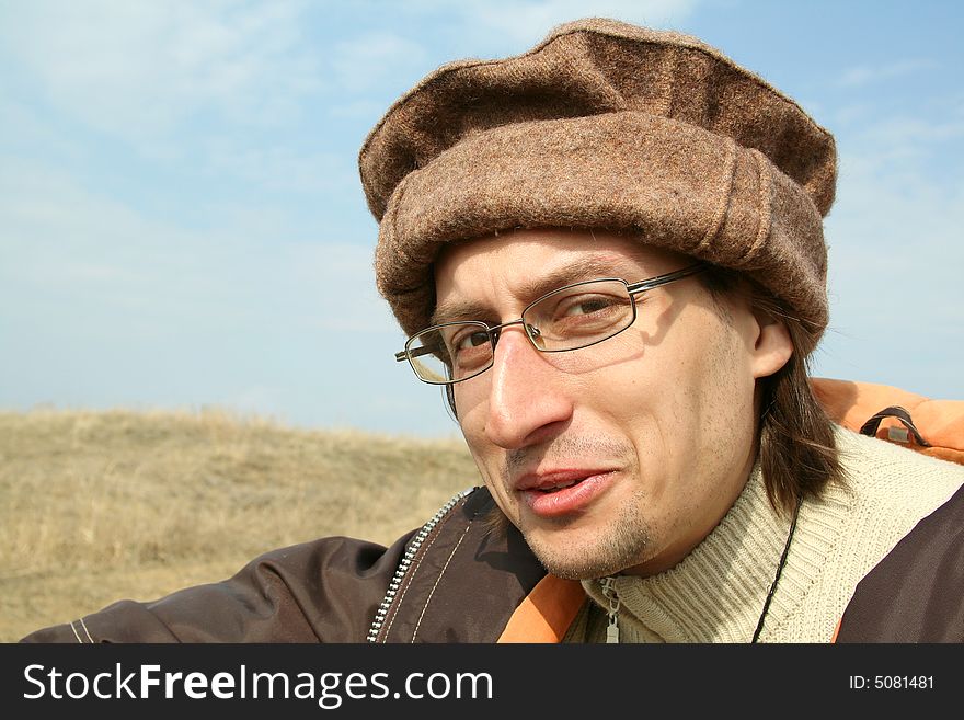 Portrait of man in hat on background of nature