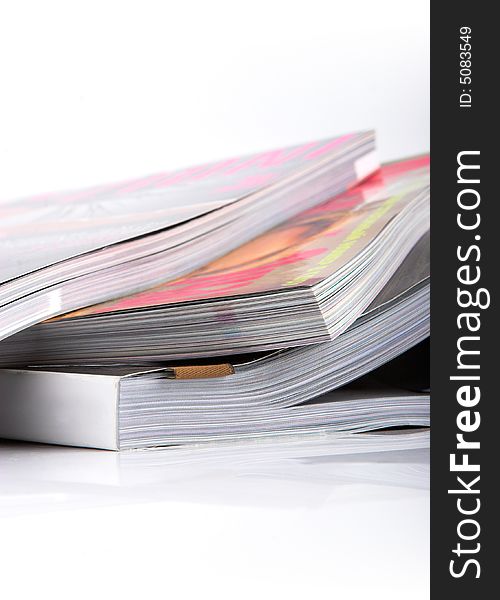 Stack of glossy magazines on a white background.