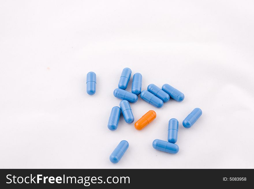 Set of blue and orange pills, white background