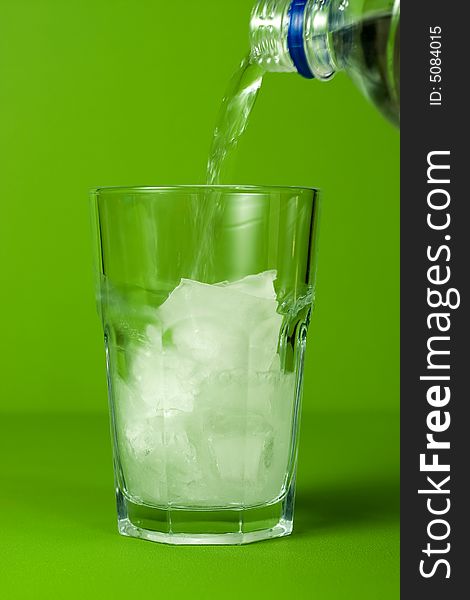 Glass of sparkling water on green background