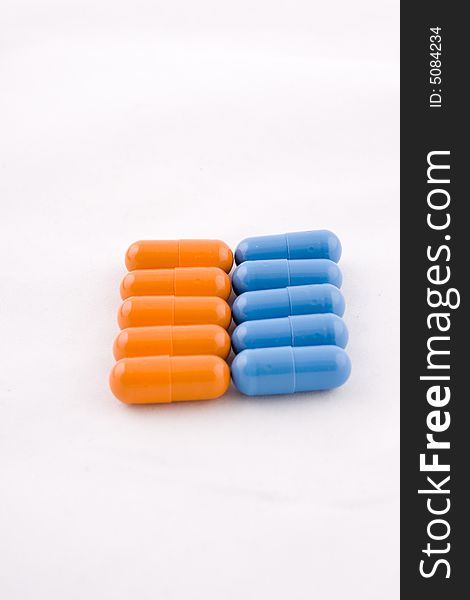 Set of blue and orange pills, white background