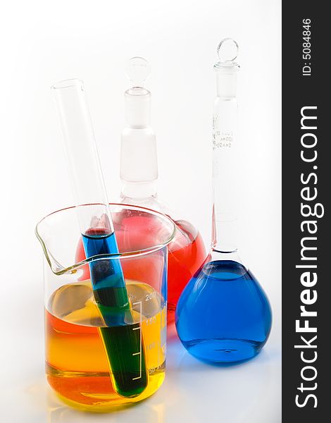 Various colorful flasks over white background
