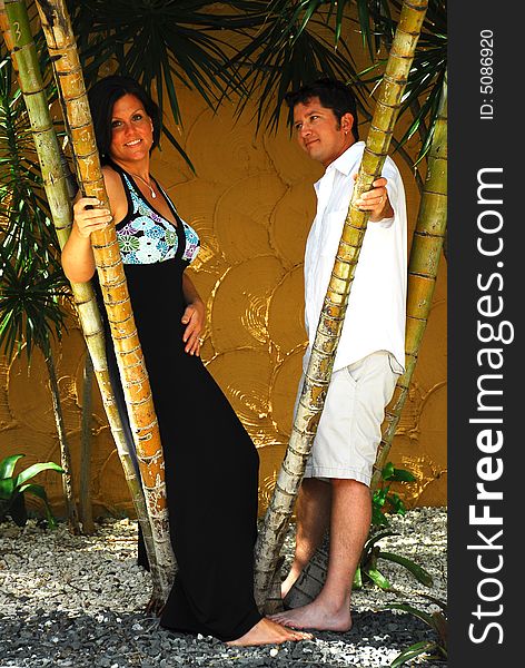 Couple posing behind bamboo shoots in a tropical location. Couple posing behind bamboo shoots in a tropical location