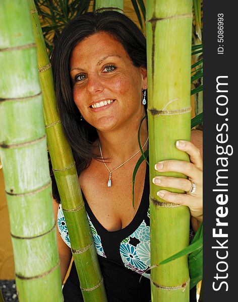 Beautiful woman posing behind bamboo shoots in a tropical location. Beautiful woman posing behind bamboo shoots in a tropical location