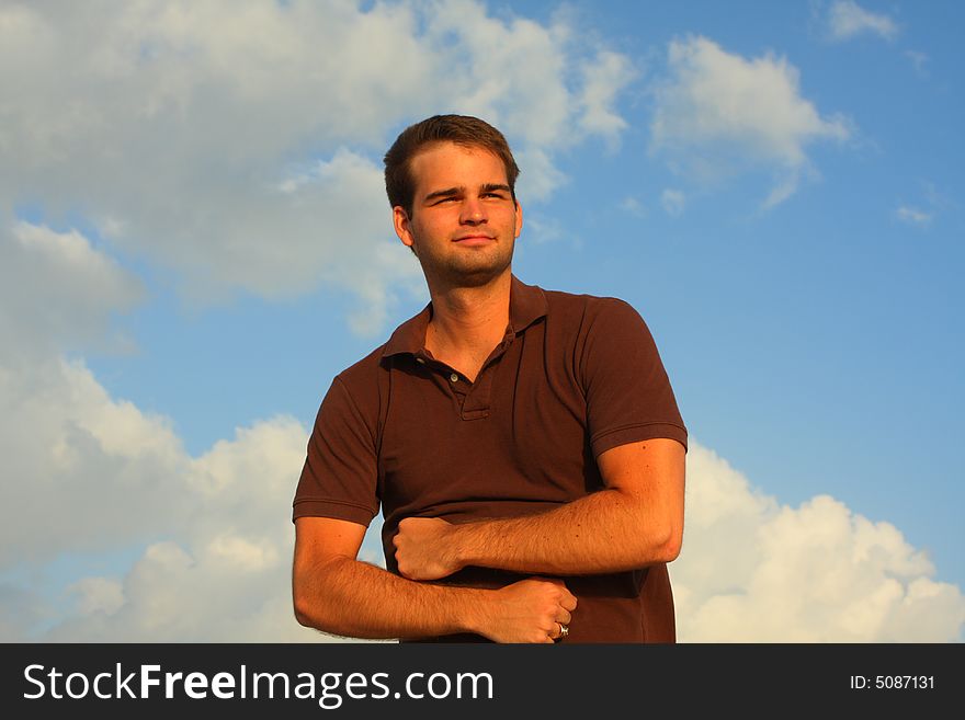 Caucasian man flexing his muscles with sky background. Caucasian man flexing his muscles with sky background.