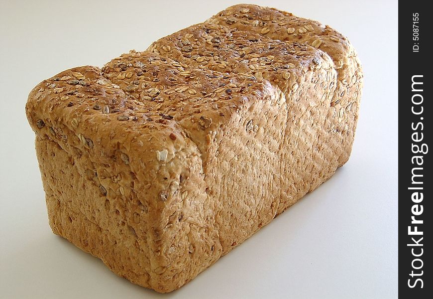 A large healthy loaf of brown bread just waiting to be sliced and eaten.