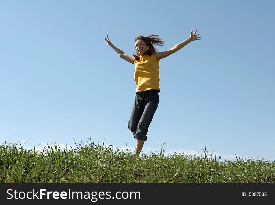 The girl jumps at top of a hill