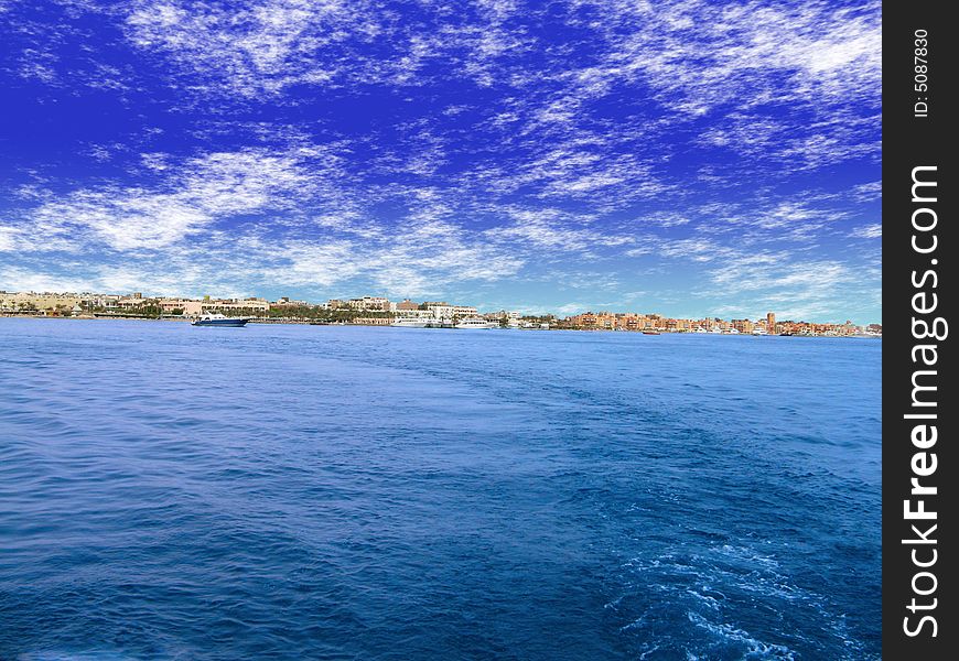 Blue sky and blue sea.View to town on shore. Blue sky and blue sea.View to town on shore