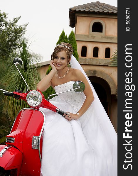 A bride sitting on a red scooter. A bride sitting on a red scooter