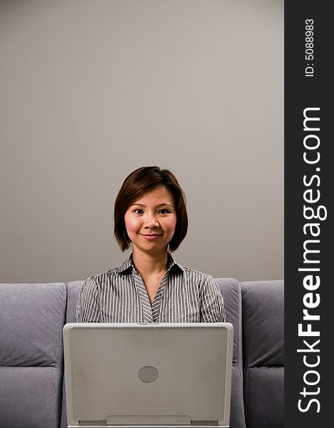 Asian lady in business attire, working on a notebook computer. Asian lady in business attire, working on a notebook computer