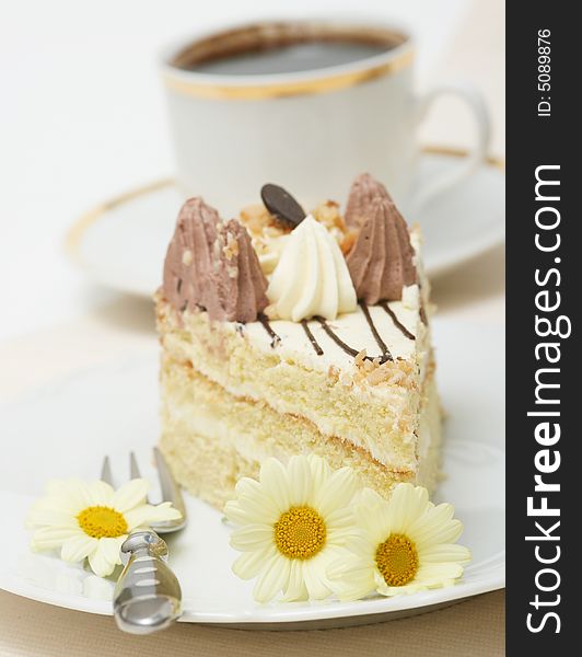 A slice of a cream cake and coffee with spring flowers. A slice of a cream cake and coffee with spring flowers.