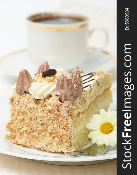 A slice of a cream cake and coffee with spring flower. A slice of a cream cake and coffee with spring flower.