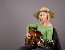 Blonde In Straw Hat Posing With Guitar Royalty Free Stock Photos