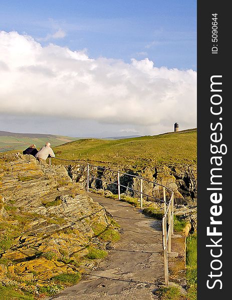 A couple admiring the landscape, Peel, Isle of Man. A couple admiring the landscape, Peel, Isle of Man