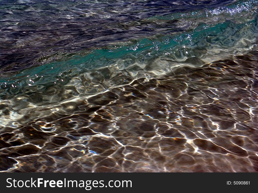 The clear sea water and waves with sun reflections are on the picture . The dom of sea can be seen through it. The clear sea water and waves with sun reflections are on the picture . The dom of sea can be seen through it.