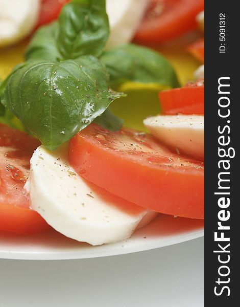 Close up of mozzarella tricolore salad with tomatoes and basil with drizzling of olive oil. Close up of mozzarella tricolore salad with tomatoes and basil with drizzling of olive oil.