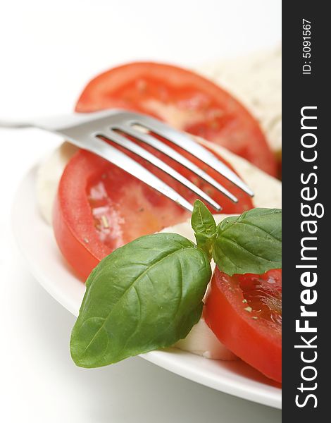 Close up of mozzarella tricolore salad with tomatoes and basil with drizzling of olive oil. Close up of mozzarella tricolore salad with tomatoes and basil with drizzling of olive oil.