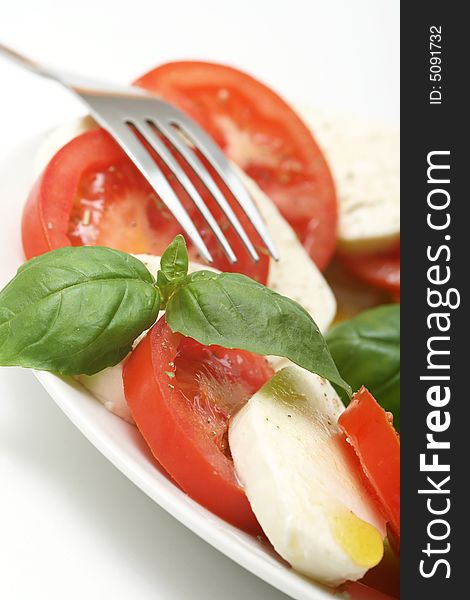 Close up of mozzarella tricolore salad with tomatoes and basil with drizzling of olive oil. Close up of mozzarella tricolore salad with tomatoes and basil with drizzling of olive oil.