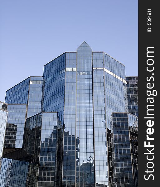 A modern blue glass financial center reflecting surroundings. A modern blue glass financial center reflecting surroundings