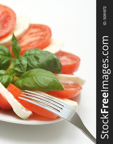 Close up of mozzarella tricolore salad with tomatoes and basil with drizzling of olive oil. Close up of mozzarella tricolore salad with tomatoes and basil with drizzling of olive oil.