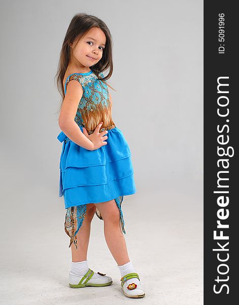 Little cute girl posing in a fancy blue dress. Little cute girl posing in a fancy blue dress