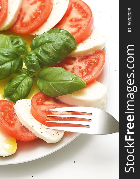 Close up of mozzarella tricolore salad with tomatoes and basil with drizzling of olive oil. Close up of mozzarella tricolore salad with tomatoes and basil with drizzling of olive oil.