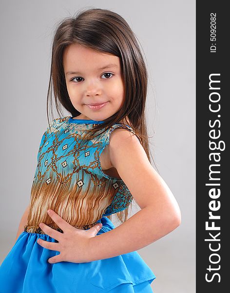 Little cute smiling girl with brown hair wearing blue dress. Little cute smiling girl with brown hair wearing blue dress