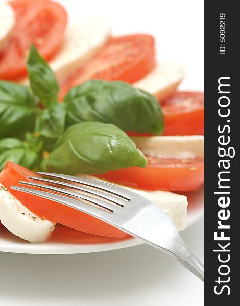 Close up of mozzarella tricolore salad with tomatoes and basil with drizzling of olive oil. Close up of mozzarella tricolore salad with tomatoes and basil with drizzling of olive oil.