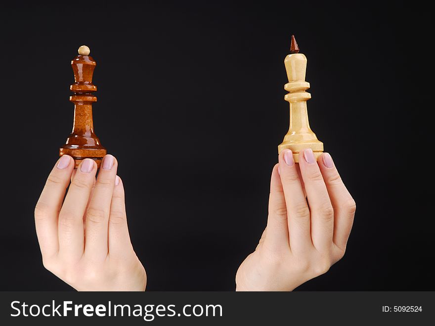 Two hands with black and white chesspieces. Two hands with black and white chesspieces