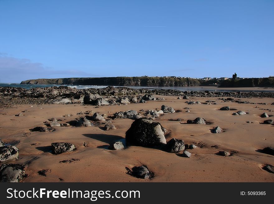 A rocky beach on the west of ireland with ballybunion castle in the background. A rocky beach on the west of ireland with ballybunion castle in the background