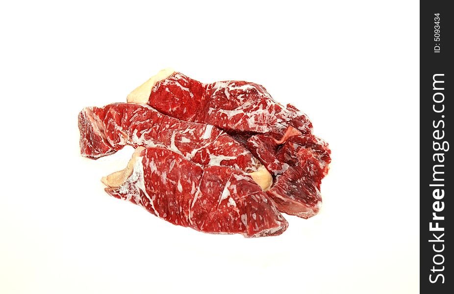 Peace of frozen steak in a white isolated background. Peace of frozen steak in a white isolated background