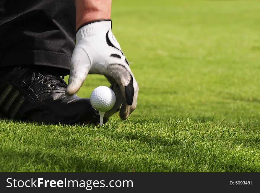 Ball and tee with hand for using as background. Ball and tee with hand for using as background